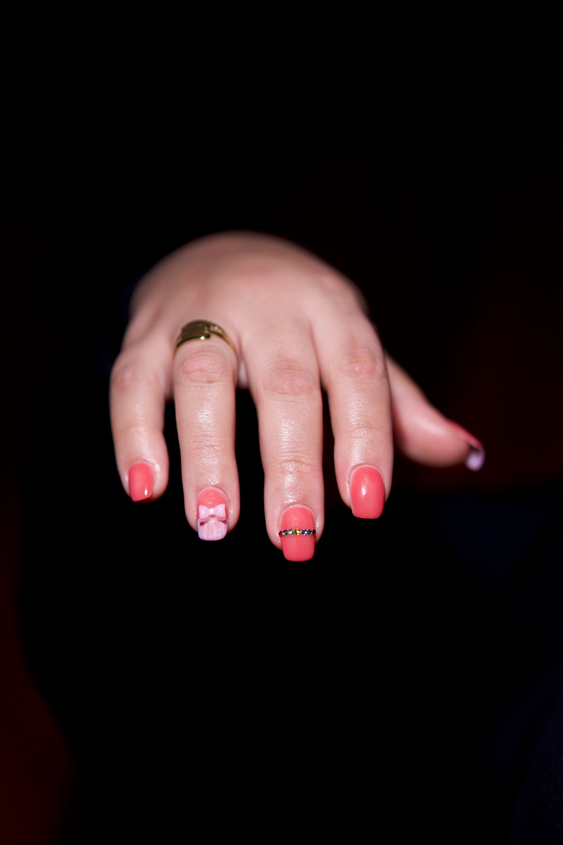 Hand with detailed nail art against a dark background