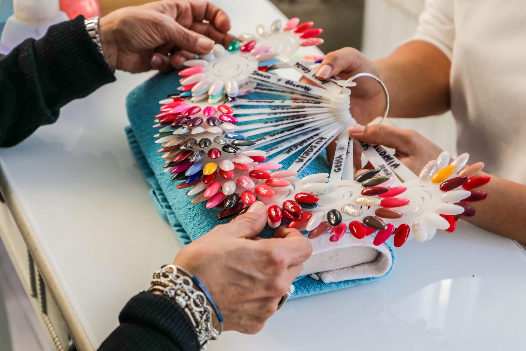 Nail technician showing a client colour swatches